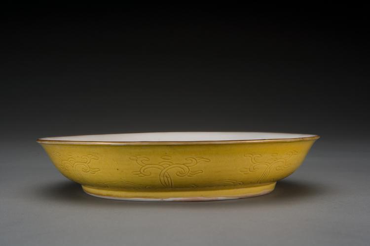 康熙款黄釉白里暗花纹盘