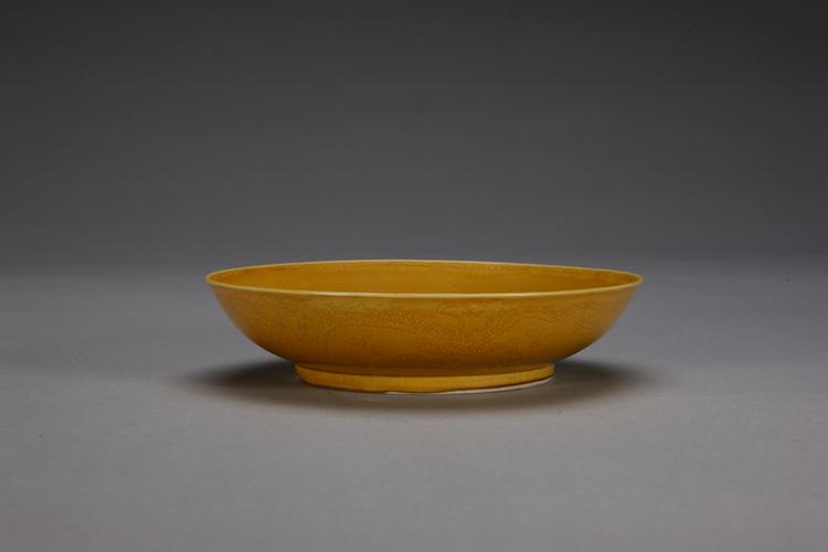 康熙款黄釉暗划龙凤纹盘