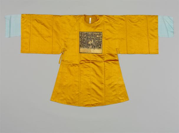 杏黄色素缎缀平金绣鹤纹方补女官衣